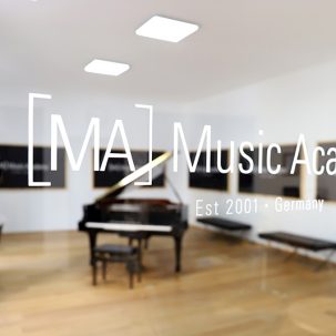 Schriftzug der Music Academy mit Blick in den Proberaum und Flügel