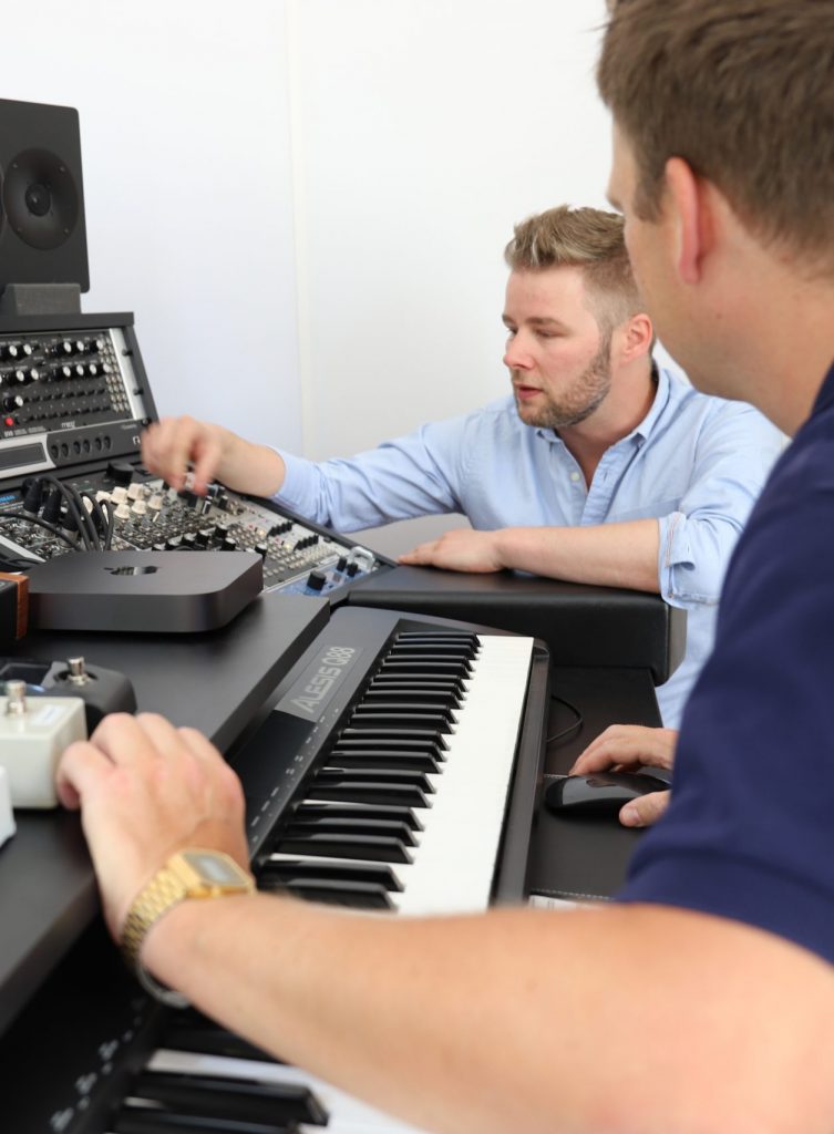 Dozent zeigt dem Schüler die Musikproduktion