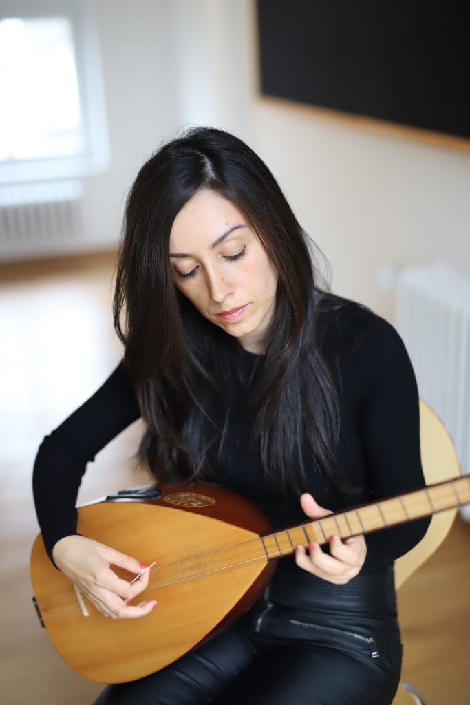 Eine junge Dozentin spielt versunken auf der Saz